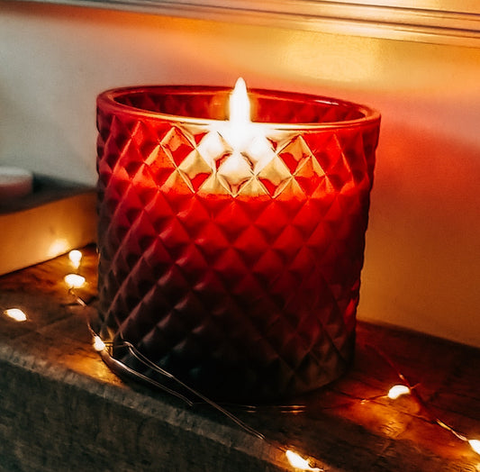 Gingerbread candle in burgundy geo jar lit on mantelpiece